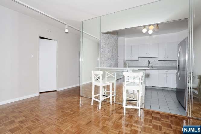 6 Horizon Road, Unit 2405 Fort Lee, NJ 07024 - Photo 11 of 42 a dining table chair with a white cabinets and wooden floor