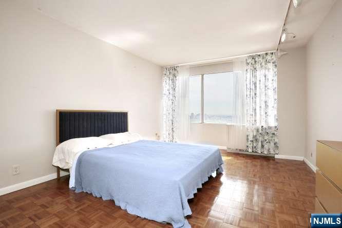 6 Horizon Road, Unit 2405 Fort Lee, NJ 07024 - Photo 20 of 42 a spacious bedroom with a bed and a window