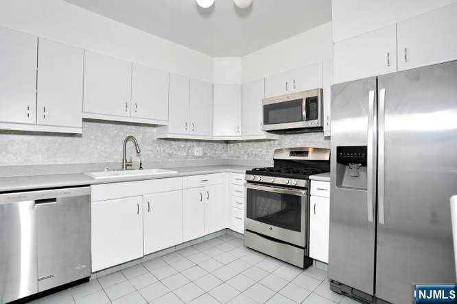 6 Horizon Road, Unit 2405 Fort Lee, NJ 07024 - Photo 7 of 42 a kitchen with cabinets stainless steel appliances and a sink