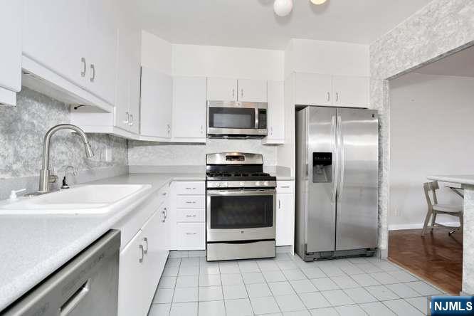 6 Horizon Road, Unit 2405 Fort Lee, NJ 07024 - Photo 9 of 42 a kitchen with a sink stainless steel appliances and cabinets