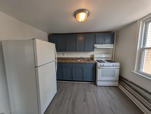 a kitchen with a refrigerator and a stove