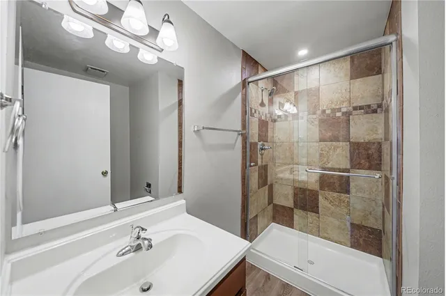 a bathroom with a shower sink and mirror