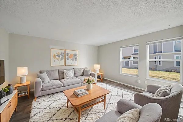 a living room with furniture and a flat screen tv with wooden floor