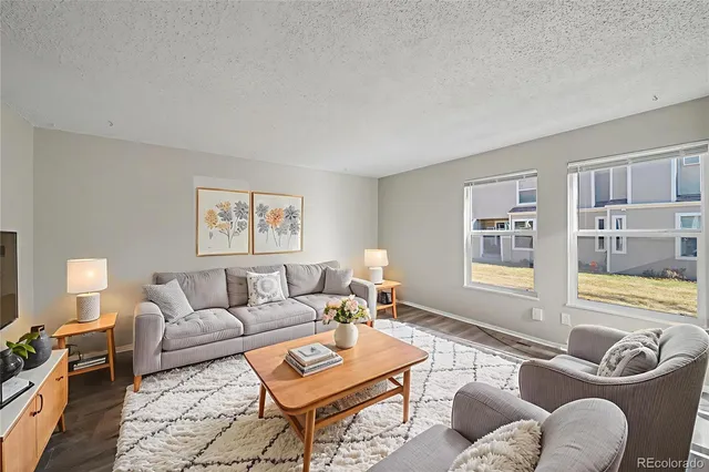 a living room with furniture and a flat screen tv with wooden floor