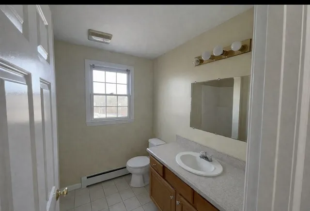 a bathroom with a granite countertop sink toilet and mirror