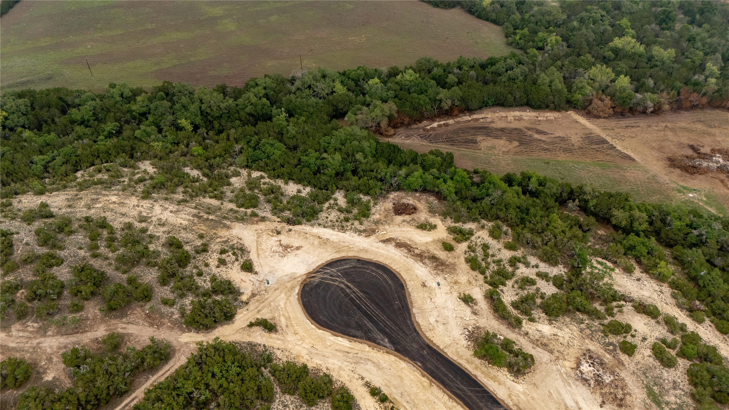 Lot 25 Ranch Road 165 Dripping Springs, TX 78620 - Photo 2 of 8 New cul-de-sac development featuring paved road surfaces, dense tree lines, and surrounding natural terrain
