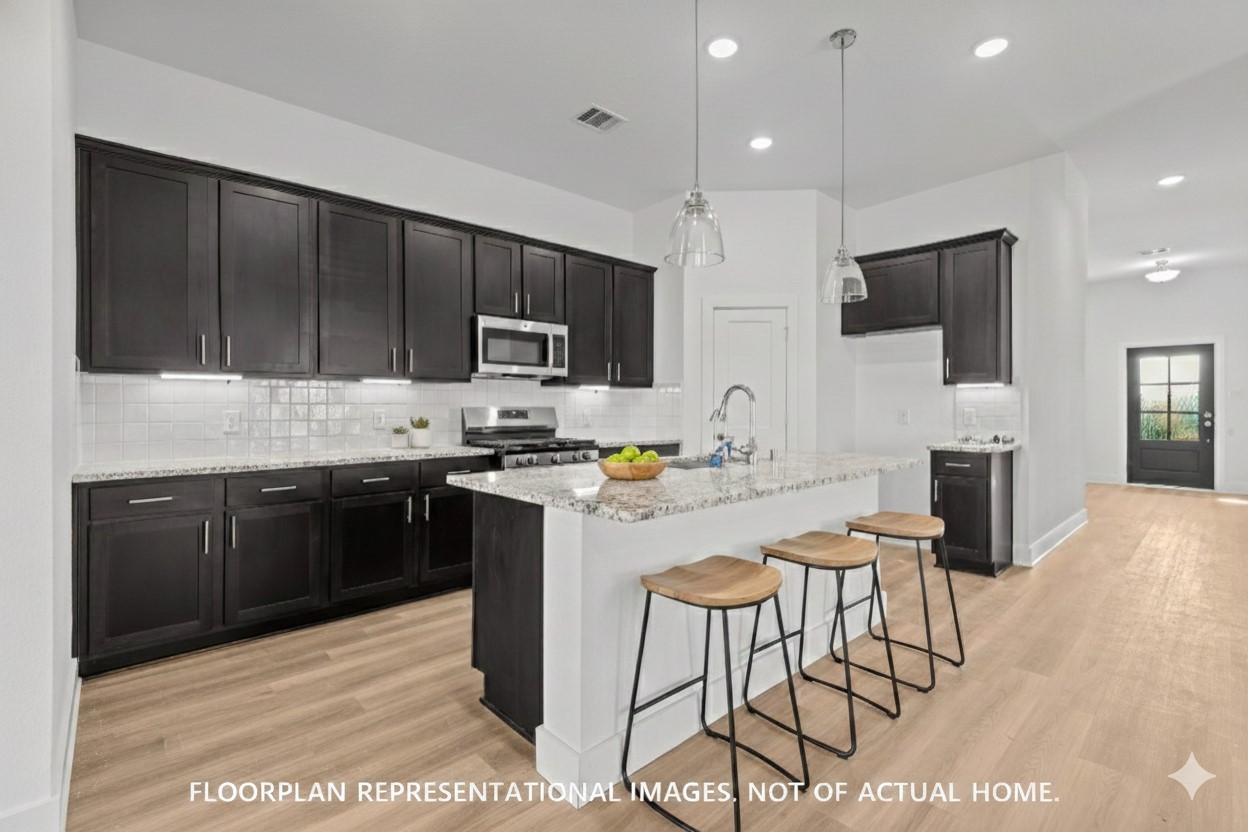 2119 Lone Bronco Boulevard Rosenberg, TX 77471 - Photo 7 of 12 a kitchen with a sink a microwave and cabinets