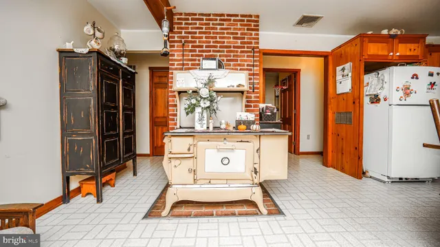a living room with stainless steel appliances furniture a chandelier and a dining table view