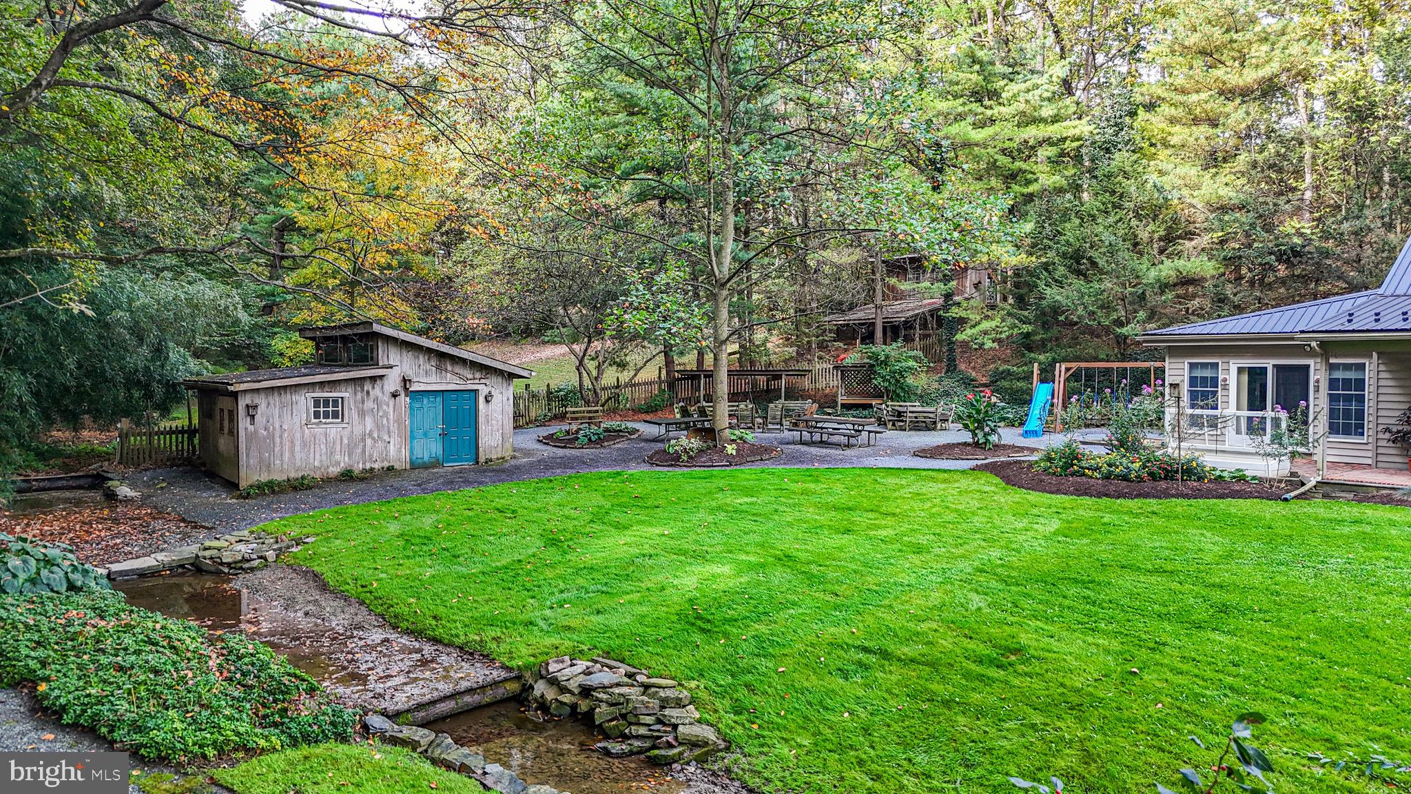 240 Evans Road Lititz, PA 17543 - Photo 63 of 77 a backyard of a house with table and chairs plants and large tree
