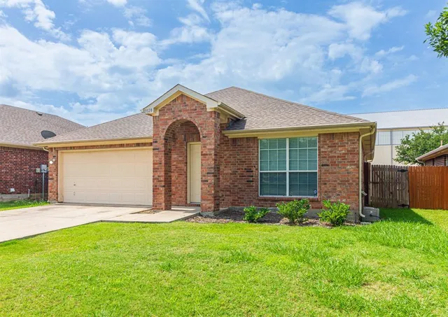 a front view of a house with a garden and yard