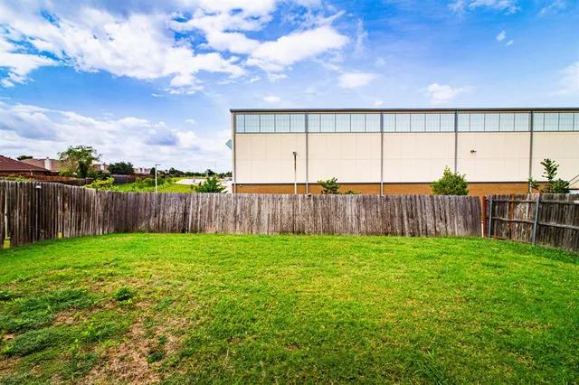 a view of a backyard with wooden fence