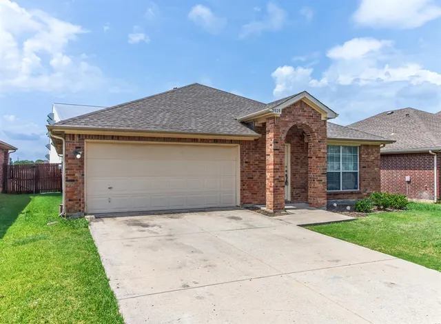 a front view of a house with a garden and garage
