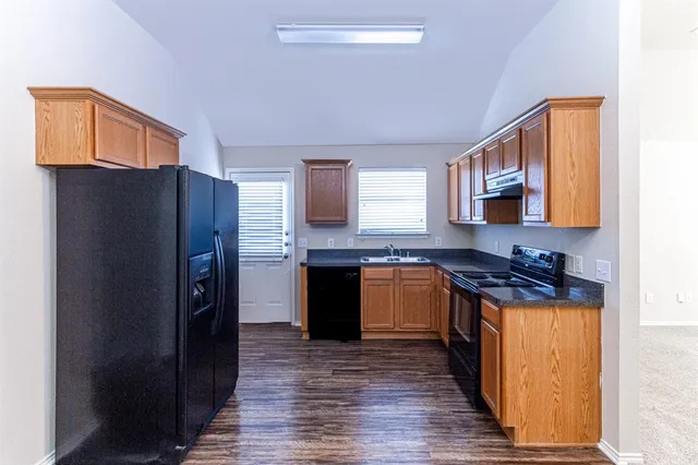 a kitchen with stainless steel appliances granite countertop a refrigerator and a stove top oven