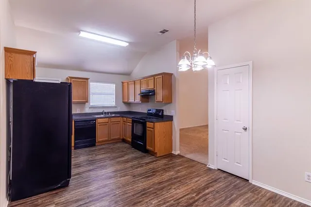 a kitchen with kitchen island granite countertop wooden floors and stainless steel appliances