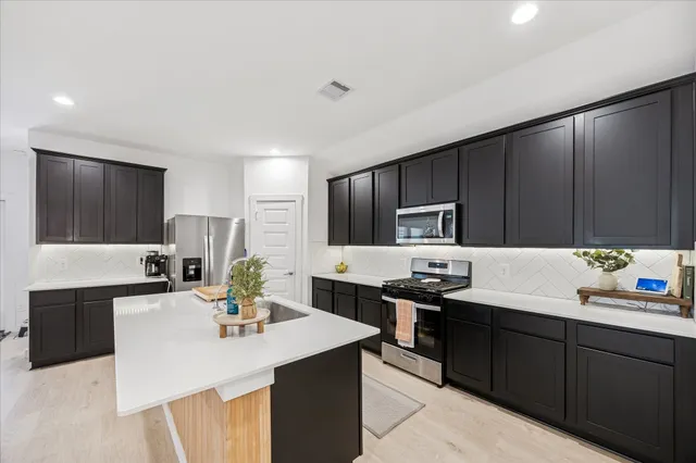 a kitchen with a sink stove and microwave