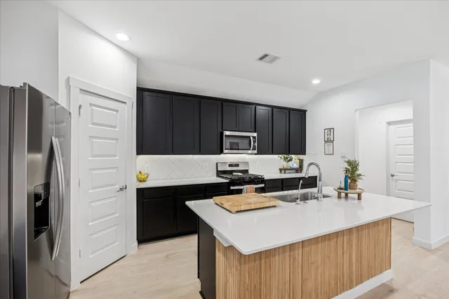 a spacious bedroom with a bed and a chandelier
