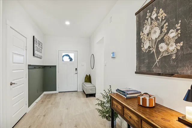 a living room with furniture kitchen view and a wooden floor