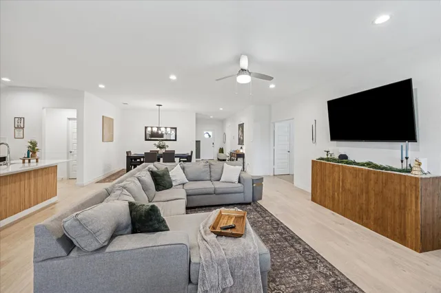 a living room with furniture a flat screen tv and kitchen view