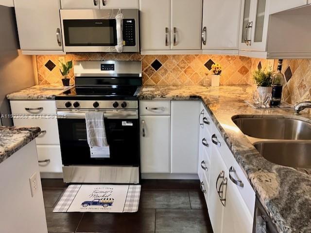 3910 Inverrary Boulevard, Unit 304B Lauderhill, FL 33319 - Photo 19 of 22 a kitchen with granite countertop a stove and a sink