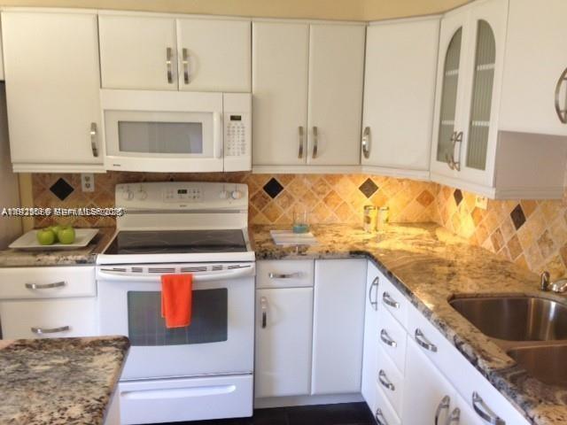 3910 Inverrary Boulevard, Unit 304B Lauderhill, FL 33319 - Photo 2 of 22 a kitchen with granite countertop a sink and a stove