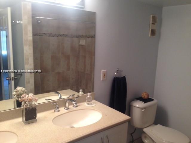 3910 Inverrary Boulevard, Unit 304B Lauderhill, FL 33319 - Photo 5 of 17 a bathroom with a sink toilet and a mirror