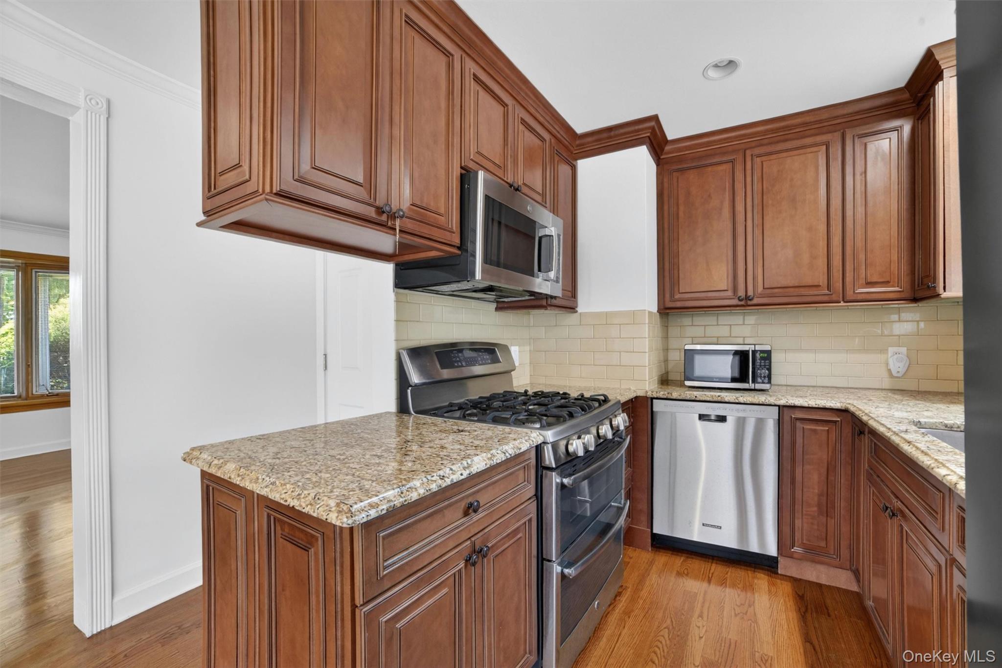 263 Croydon Road Yonkers, NY 10710 - Photo 9 of 43 a kitchen with stainless steel appliances granite countertop a stove top oven a sink dishwasher and wooden cabinets with wooden floor