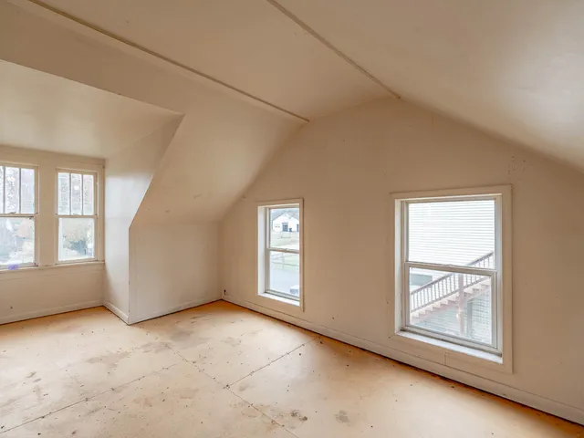 an empty room with windows and closet