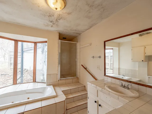 a bathroom with a tub sink and mirror