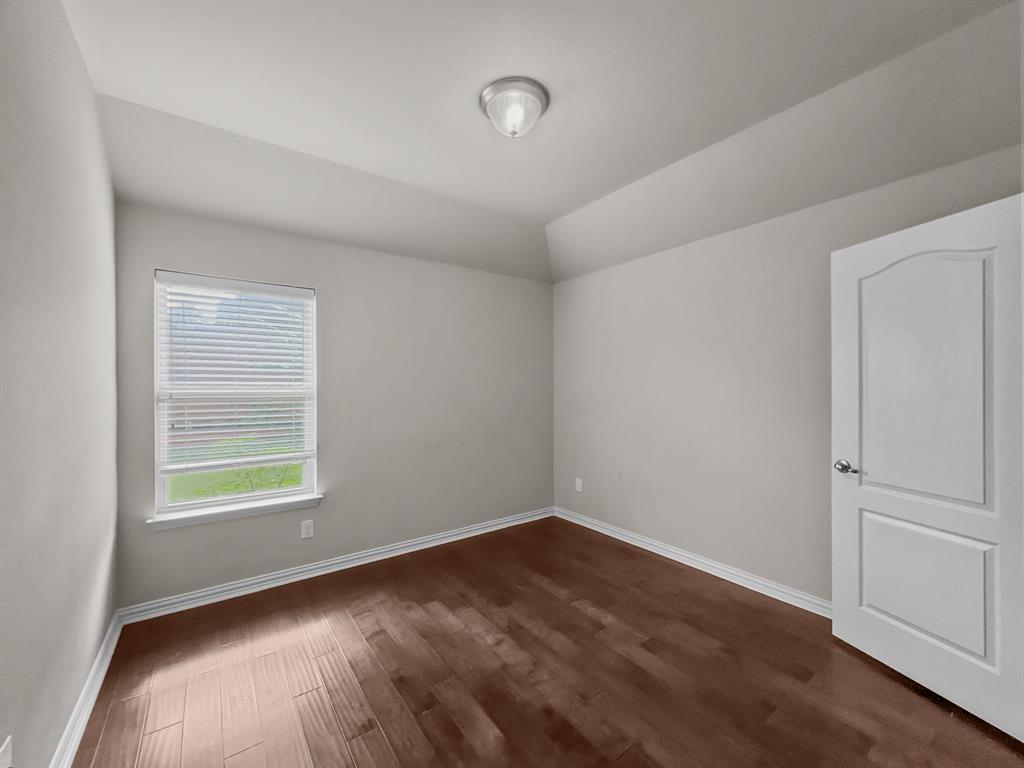 3205 Ridgeway Drive McKinney, TX 75071 - Photo 16 of 27 an empty room with wooden floor and windows