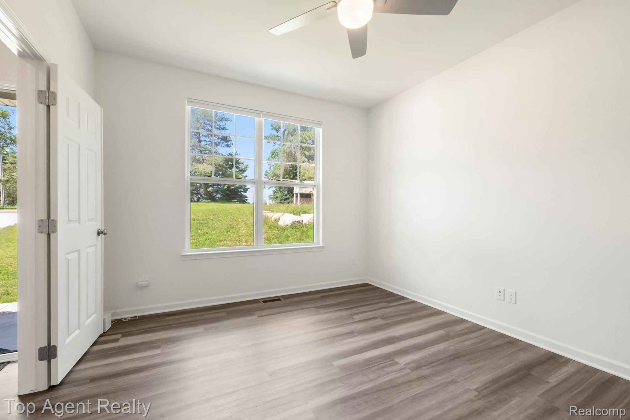 63770 Dequindre Road Washington, MI 48095 - Photo 7 of 61 Bright room featuring wood-finish flooring, white trim, and a ceiling fan with integrated lighting