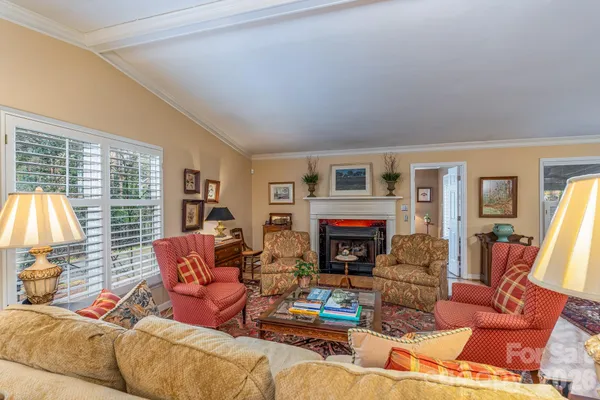 a living room with furniture large window and a fireplace
