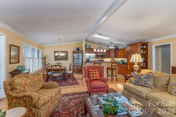 a living room with furniture kitchen view and a window