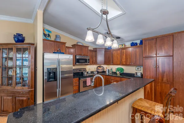a kitchen with stainless steel appliances granite countertop a sink a stove and a refrigerator