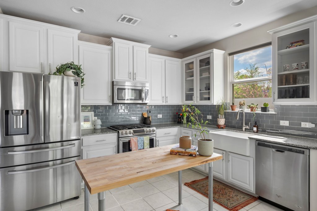 610 Bernstein Street, Unit 14 Austin, TX 78745 - Photo 11 of 39 Kitchen featuring stainless steel appliances, light stone counters, white cabinetry, glass fronted cabinets, and recessed lighting