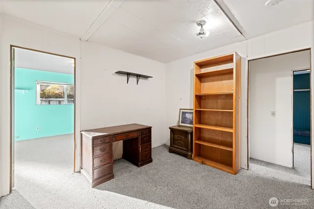 a view of an empty room with wooden floor and windows