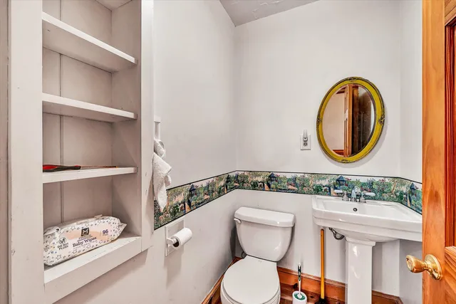 a bathroom with a toilet a sink and a mirror