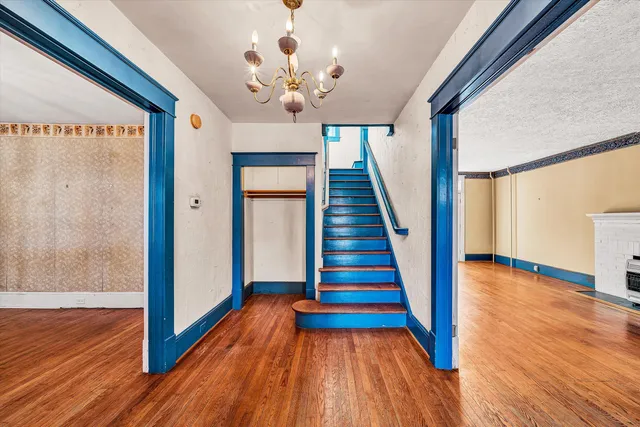 a view of a hallway with wooden floor and staircase