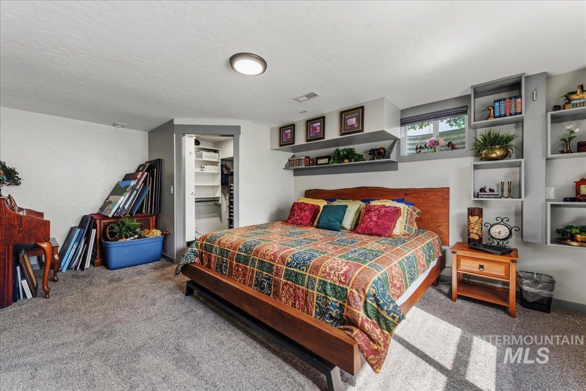 6323 Foothill Road Star, ID 83669 - Photo 21 of 50 Carpeted room featuring a wood-finish bed frame with an integrated headboard, built-in shelving, a recessed window, and a closet with bifold doors