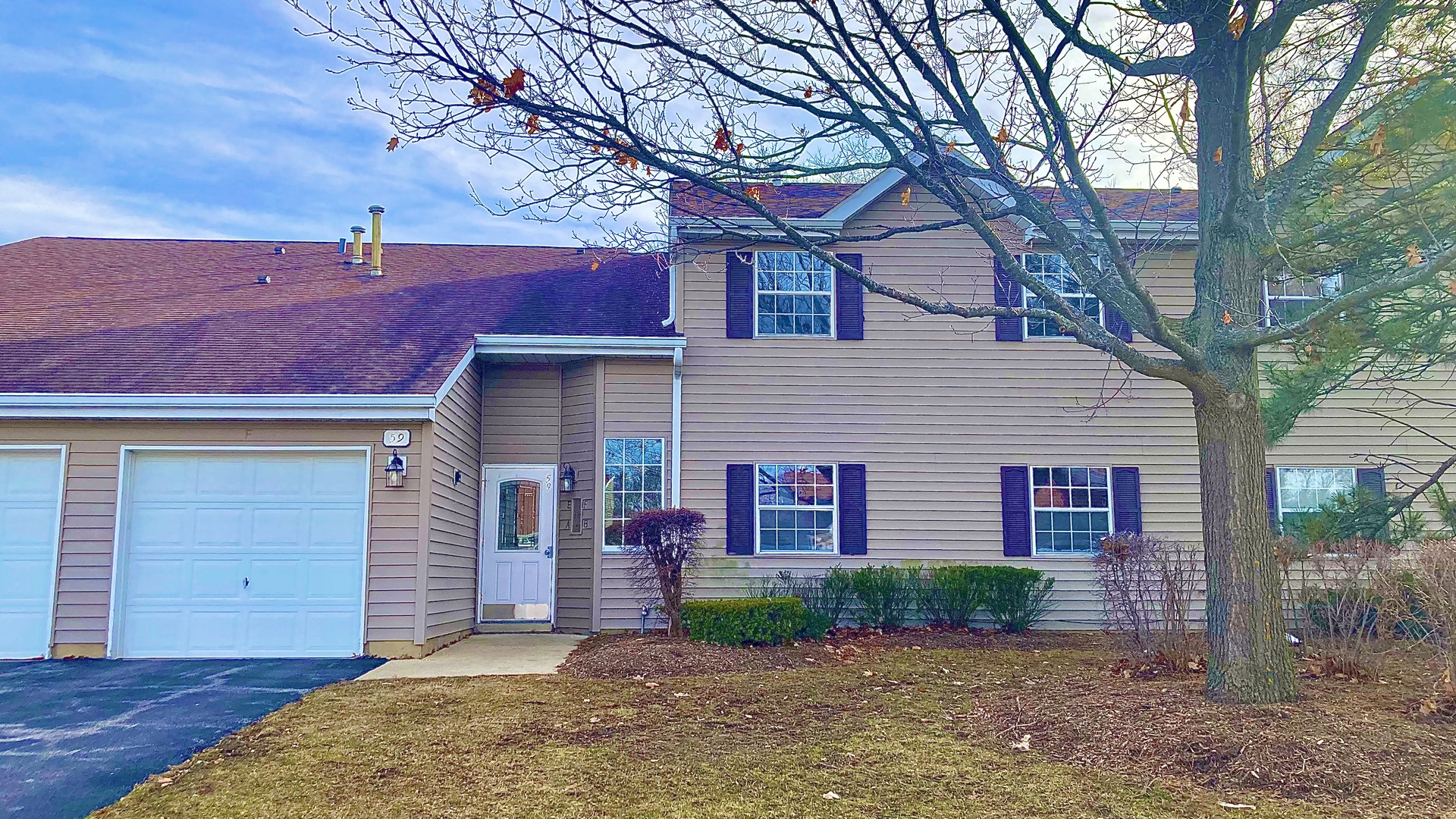 59 Gant Circle, Unit F Streamwood, IL 60107 - Photo 1 of 18 a front view of a house with a yard and garage