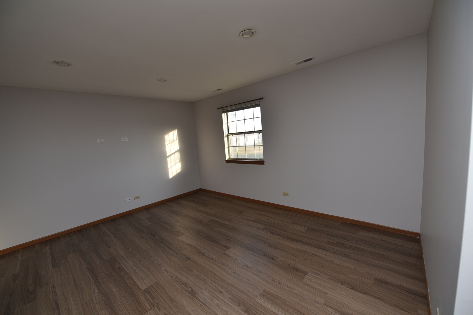 59 Gant Circle, Unit F Streamwood, IL 60107 - Photo 11 of 18 an empty room with wooden floor and windows