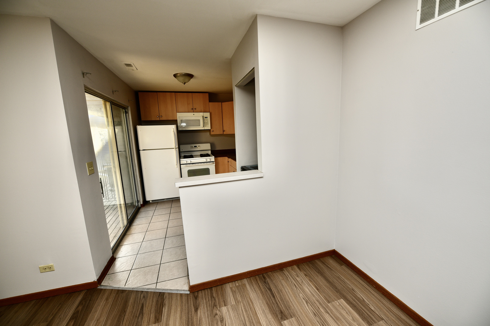 59 Gant Circle, Unit F Streamwood, IL 60107 - Photo 7 of 18 a view of a hallway to a livingroom with wooden floor