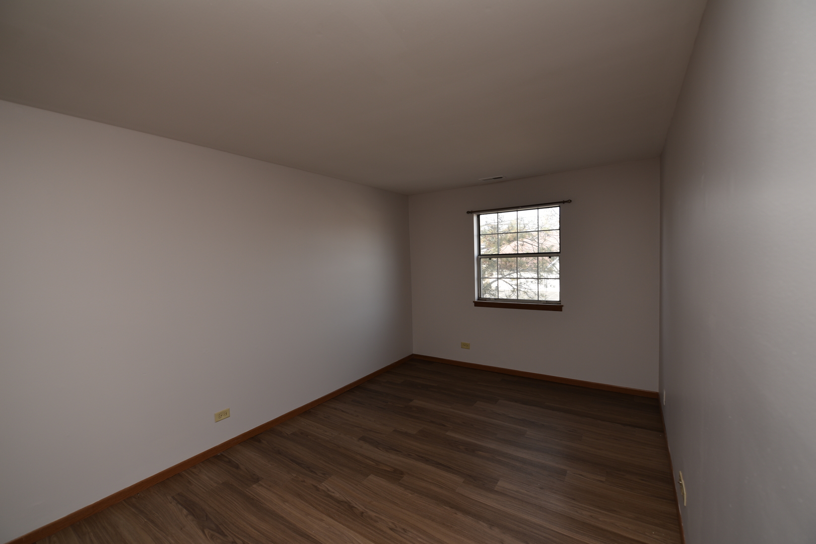 59 Gant Circle, Unit F Streamwood, IL 60107 - Photo 8 of 18 a view of an empty room with wooden floor and a window