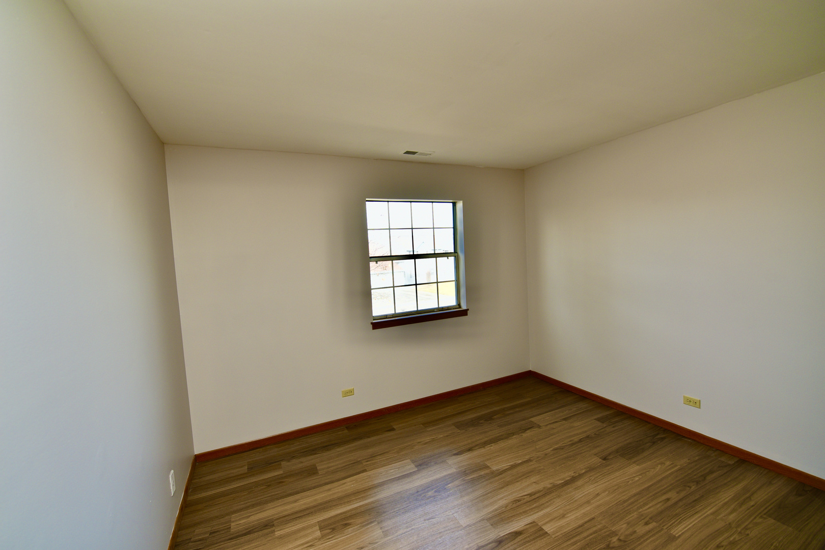 59 Gant Circle, Unit F Streamwood, IL 60107 - Photo 9 of 18 an empty room with wooden floor and windows
