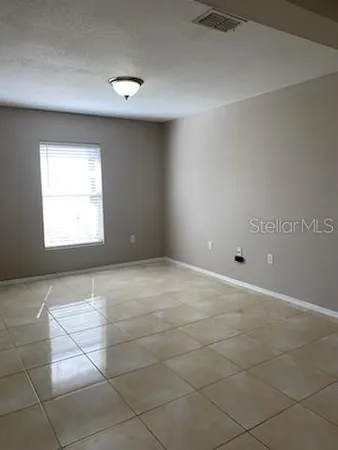 a view of a livingroom with a chandelier fan and window