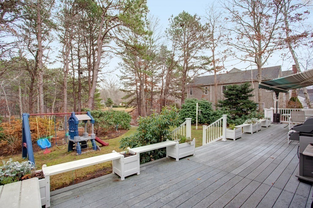 55 Pond Circle Mashpee, MA 02649 - Photo 28 of 40 a view of a patio with couches and table and chairs with wooden floor and fence