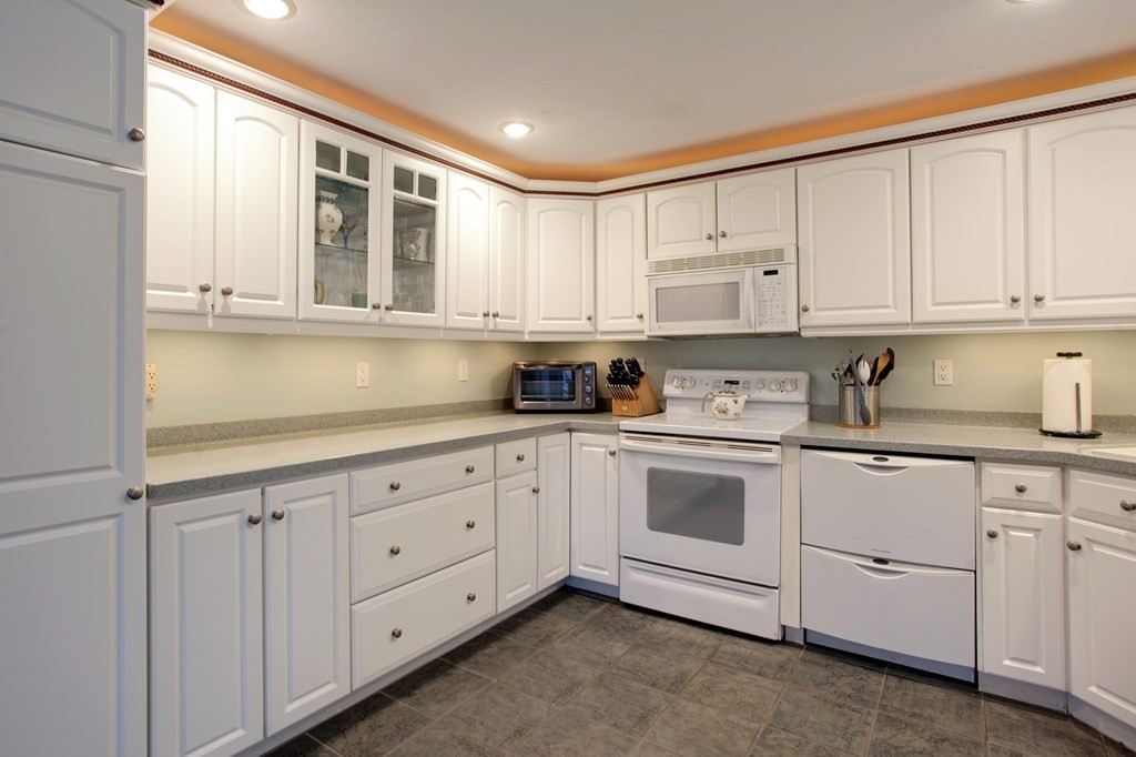55 Pond Circle Mashpee, MA 02649 - Photo 4 of 40 a kitchen with white cabinets and white appliances