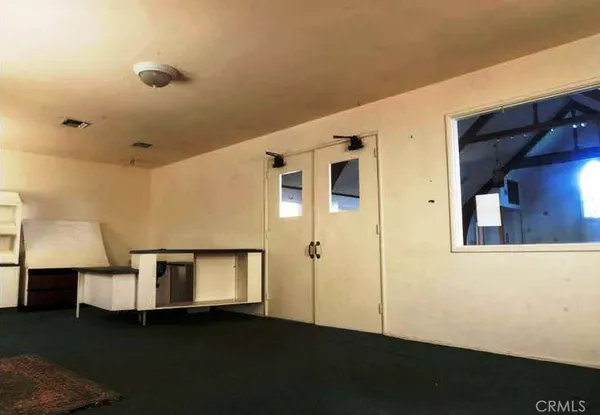 a view of an empty room with wooden floor and a cabinet