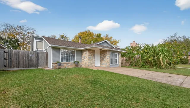 a front view of a house with a garden and yard