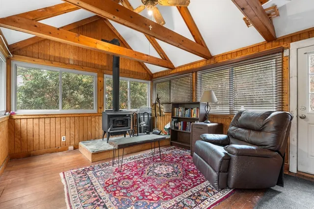 a living room with furniture a rug a lamp and a large window