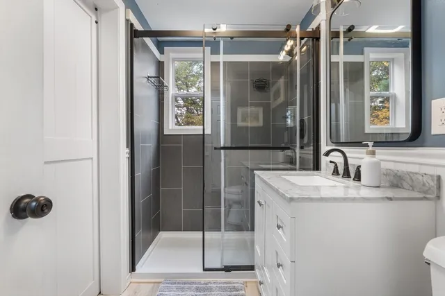 a bathroom with a shower sink and mirror